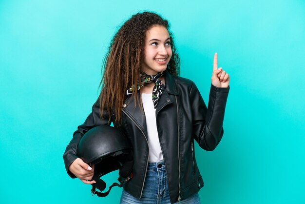 Junge arabische Frau mit einem Motorradhelm isoliert auf blauem Hintergrund, der auf eine großartige Idee zeigt