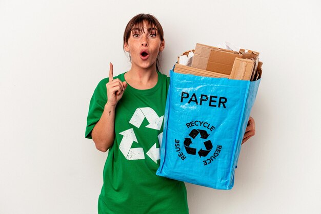 Junge argentinische Frau Recyclingpapier isoliert auf gelbem Hintergrund mit einer Idee, Inspirationskonzept.