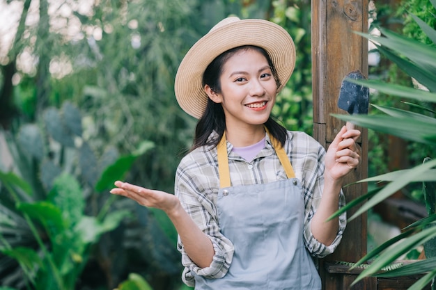 Junge Asiatin kümmert sich um den Garten