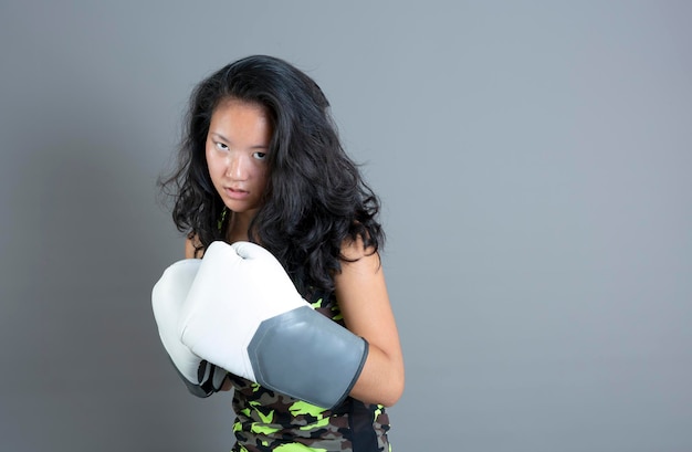 Junge Asiatin mit Boxhandschuhen