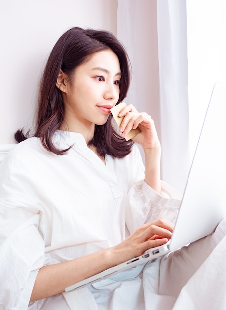 Junge asiatische Beauty-Shopping online mit Kreditkarte und Laptop