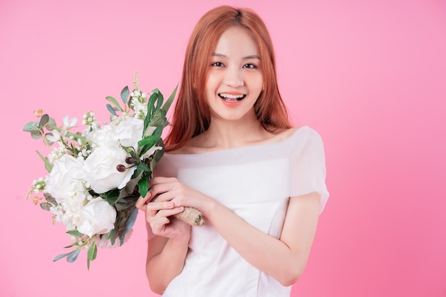 Junge asiatische Braut posiert auf rosa Hintergrund