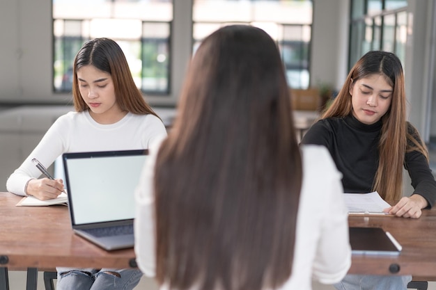 Junge asiatische College-Studenten treffen sich mit Lehrerberatern oder Tutoren, um das Projekt zu besprechen