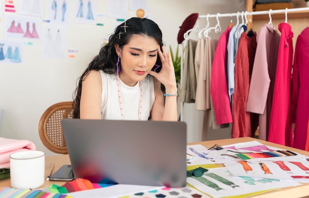 Junge asiatische Designerin betont Arbeitsdesign kreativ, während sie im Bürostudio sitzt