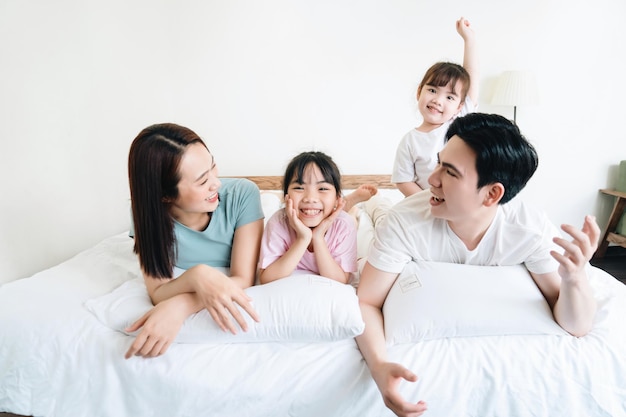 Junge asiatische Familie auf dem Bett