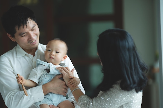 Junge asiatische Familie ist glücklich zusammen zu Hause durch das Lebensversicherungskonzept Kind Baby und Mutter und Vater haben Spaß und lächeln mit Liebe Kindheit leben in gemütlichem Lebensstil mit Vater und Mutter