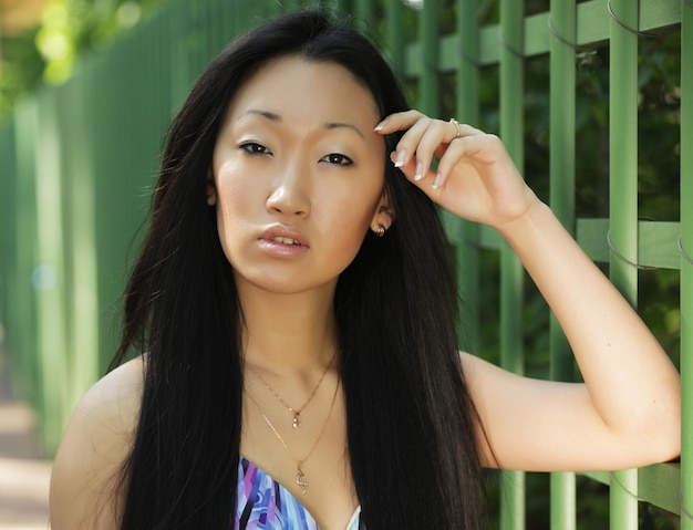 Junge asiatische Frau des Porträts im Freien