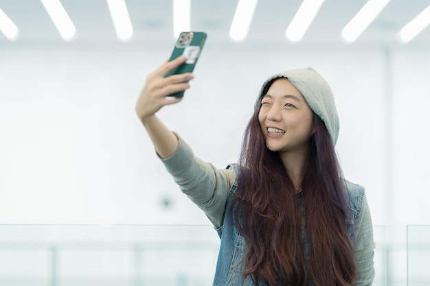 Junge asiatische Frau des schönen Porträts, die ein selfie mit intelligentem Handymädchen nimmt, fotografiert mit glücklichem und Lächeln mit Spaßlebensstilkonzept