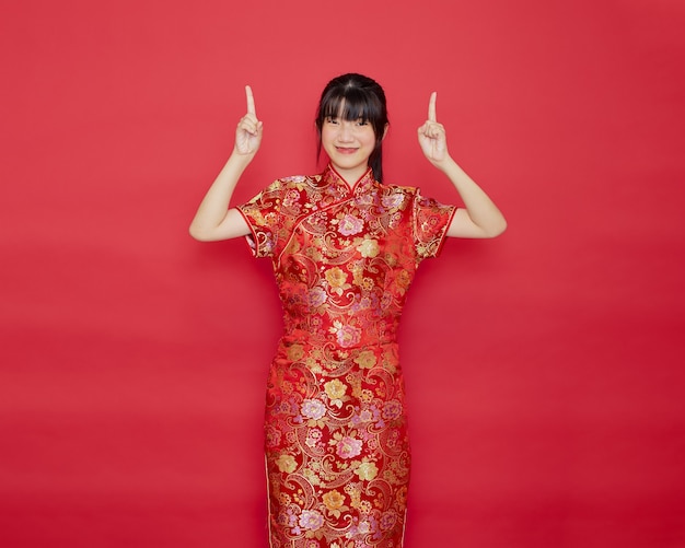 Junge asiatische Frau, die cheongsam Kleid trägt und zeigt