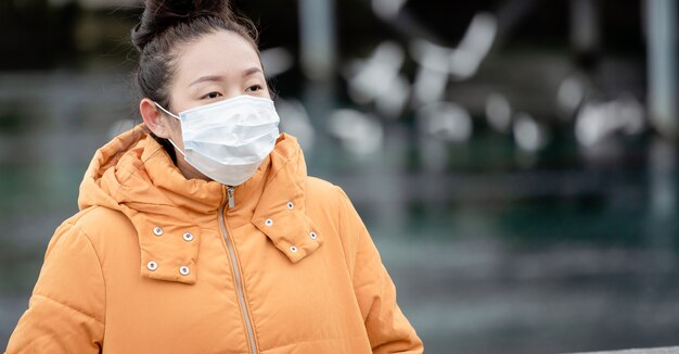 junge asiatische Frau, die eine Maske trägt, um Keime, giftige Dämpfe und Staub zu verhindern