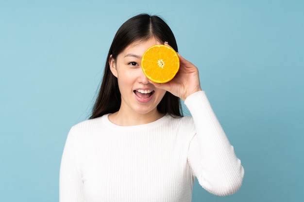 Junge asiatische Frau, die eine Orange hält