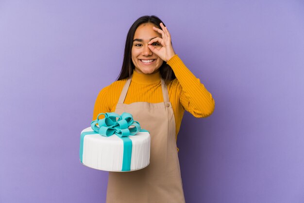 Junge asiatische Frau, die einen Kuchen hält