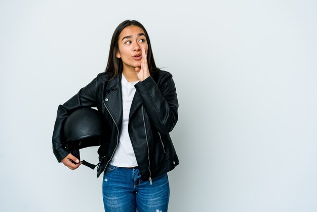 Junge asiatische Frau, die einen Motorradhelm hält, sagt eine geheime heiße Bremsnachricht und schaut zur Seite