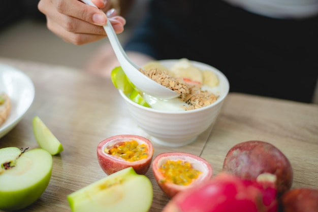 Junge asiatische Frau, die gesundes Gemüse im Lebensstil zu Hause hält, weibliche schöne vegetarische Person, die Diätnahrung macht, isst Salatmahlzeit, die Leute lächeln glücklich, gesundes Lebensmittelkonzept