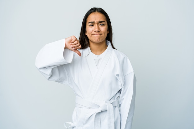 Junge asiatische Frau, die Karate lokalisiert auf weißer Wand zeigt, die eine Abneigungsgeste zeigt, Daumen nach unten. Uneinigkeit Konzept.