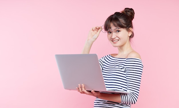 Junge asiatische Frau, die Laptop hält