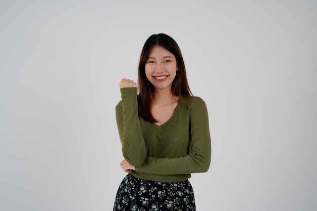 Junge asiatische Frau, die über isoliertem weißem Hintergrund steht, glückliches Gesicht, Lächeln, das in die Kamera schaut Positive Person