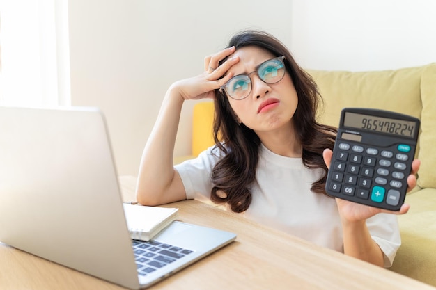 Junge asiatische Frau, die zu Hause arbeitet