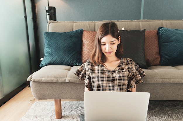 Foto junge asiatische frau, die zu hause arbeitet