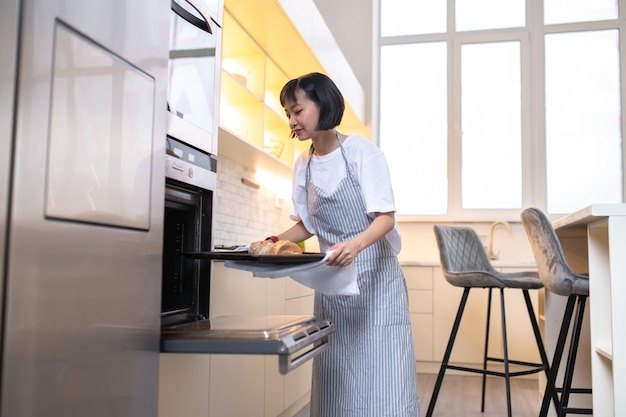 Junge asiatische Frau, die zu Hause einen Nachtisch zubereitet