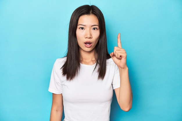 Junge asiatische Frau im weißen T-Shirt im Studio aufgenommen, als sie ein Ideen-Inspirationskonzept hatte