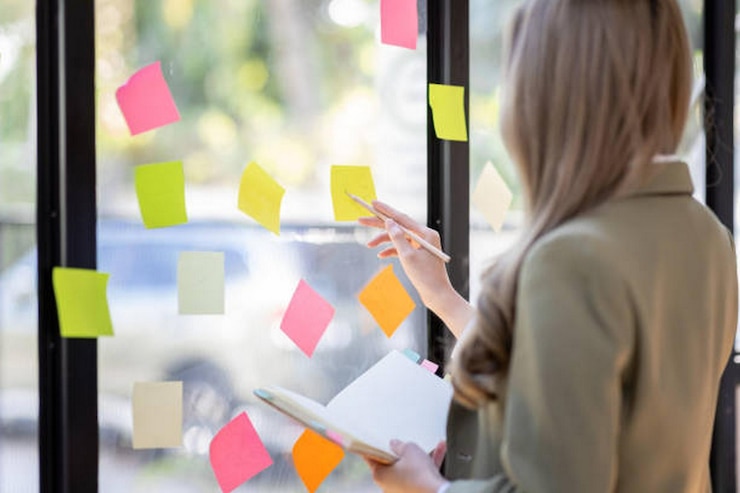 Foto junge asiatische frau kreatives team verwendet post it notizen, um ideen zu teilen klebrig notizen auf glaswand asiatische geschäftsleute design planung und brainstorming denken klebrig geschichte notizen konzept