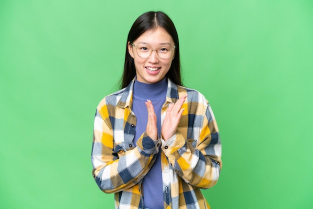 Junge asiatische Frau mit isoliertem Chroma-Key-Hintergrund applaudiert nach der Präsentation auf einer Konferenz