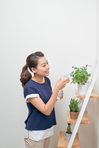 Junge asiatische Frauen erhöhen das Wasser zu Pflanzen