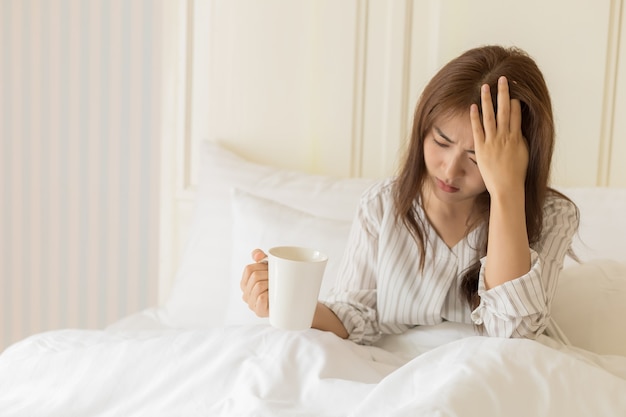 Foto junge asiatische frauen haben fieber, kopfschmerzen, migräne, müdigkeit oder stress. konzept für gesundheit und kranke.