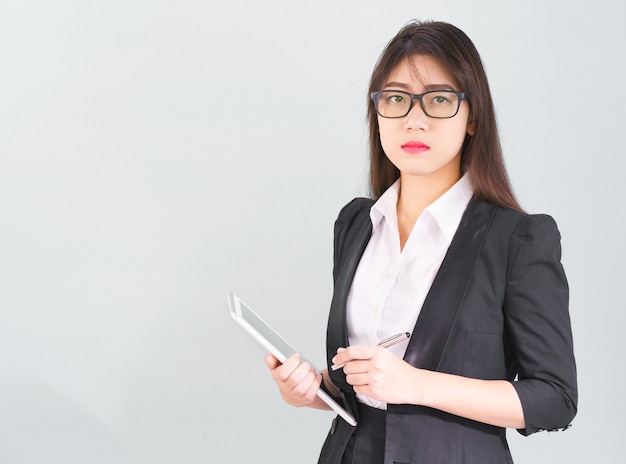 Junge asiatische Frauen passen stehend mit ihrem digitalen Tablet-Isolat auf weißem Hintergrund