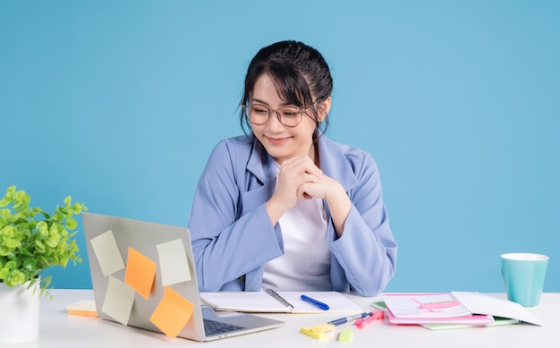 Junge asiatische Geschäftsfrau, die am Hintergrund arbeitet