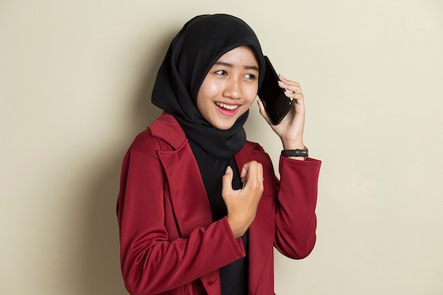 Junge asiatische Geschäftsfrau, die Hijab trägt, der am Telefon spricht