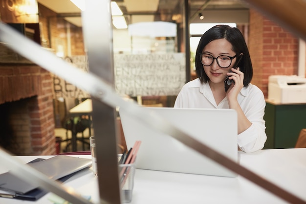 Junge asiatische Geschäftsfrau, die im Büro arbeitet