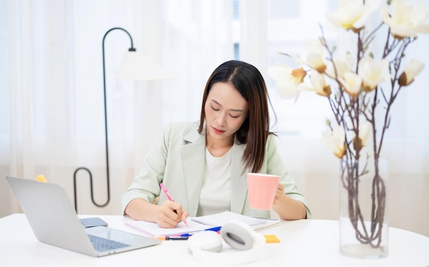 Junge asiatische Geschäftsfrau, die im Büro arbeitet