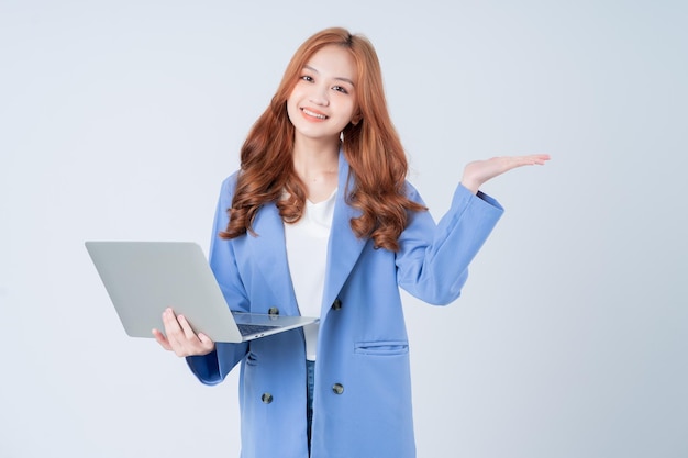 Junge asiatische Geschäftsfrau, die Laptop auf weißem Hintergrund verwendet