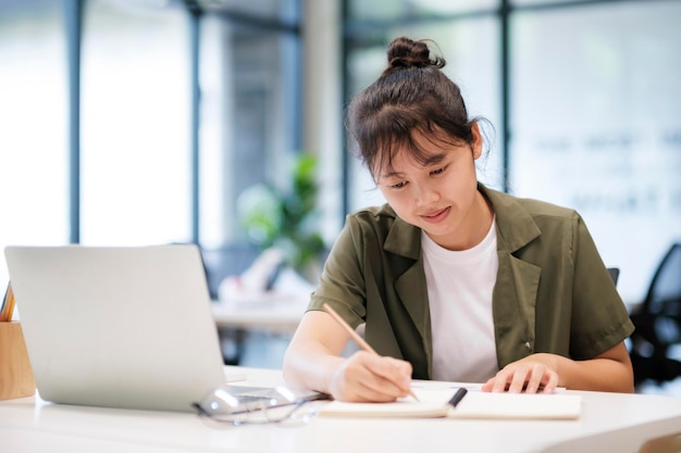 Junge asiatische Geschäftsfrau oder Studentin, die online am Computer-Laptop arbeitet