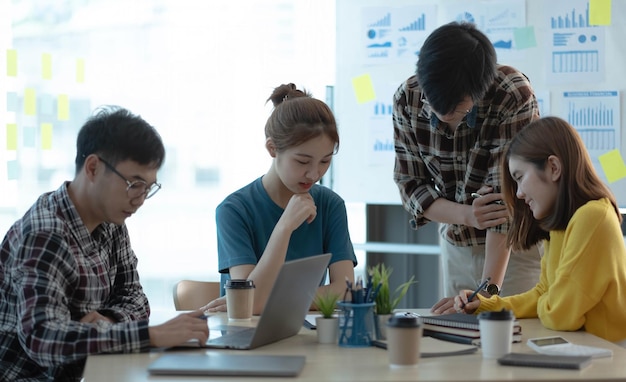 Junge asiatische Geschäftsleute, die im BüroxA zusammenarbeiten