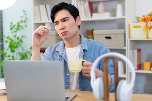 Junge asiatische Geschäftsmann arbeitet zu Hause