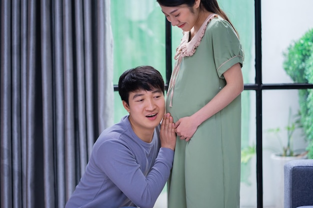 Junge asiatische Jungvermählten freuen sich, schwanger zu sein