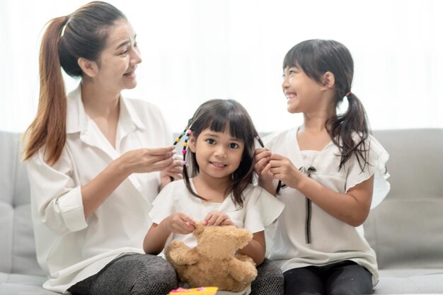 Junge asiatische Mutter, die die Haare der Tochter bindet