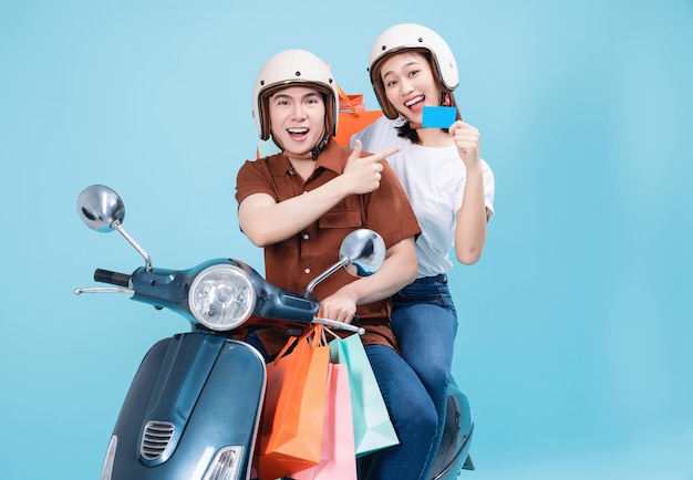 Junge asiatische Paare fahren Roller auf Hintergrund