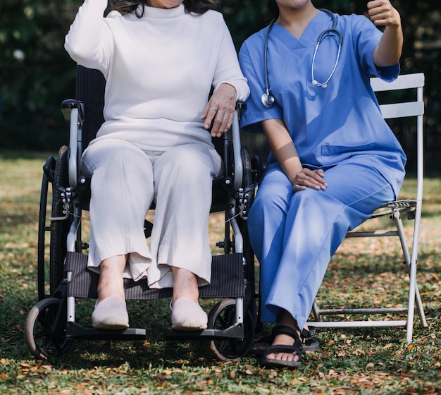 Junge asiatische Physiotherapeutin, die mit einer älteren Frau beim Gehen mit einer Gehhilfe arbeitet