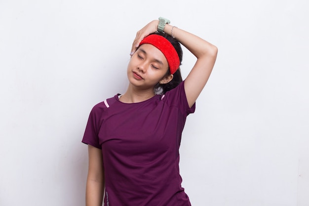 Junge asiatische sportliche Frau, die Dehnung auf weißem Hintergrund tut
