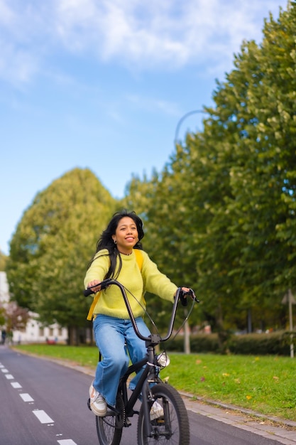 Junge asiatische Studentin lächelt mit dem Fahrrad auf dem Weg zum College gesundes Leben umweltfreundlich