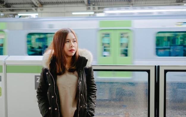 Junge asiatische Touristin im japanischen Bahnhof.