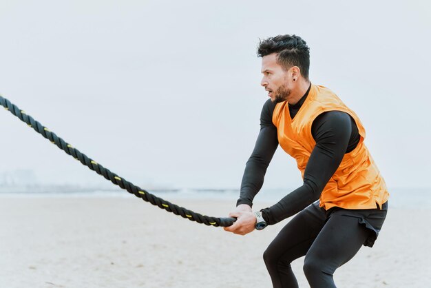 Junge Athleten trainieren morgens am Strand mit Seilen