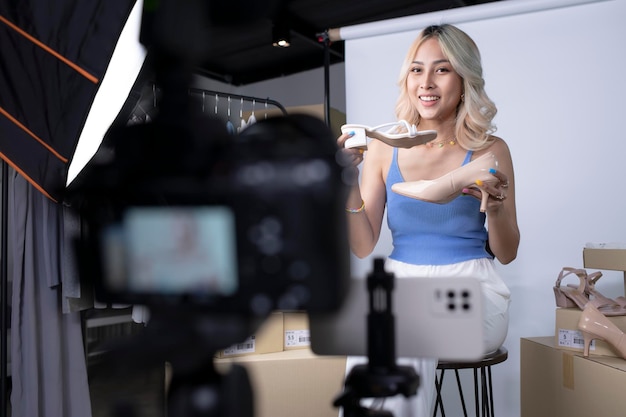 Junge attraktive asiatische Bloggerin oder Vloggerin mit Blick auf die Kamera, die das Produkt überprüft Moderne Geschäftsfrau, die soziale Medien für das Marketing nutzt Business Online Influencer on Social Media Concept