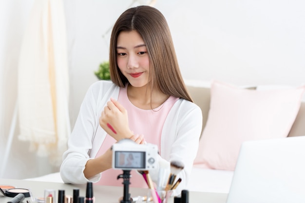 Junge attraktive asiatische Frau Schönheit vlogger Test Lippenstift auf dem Handrücken vor der Kamera