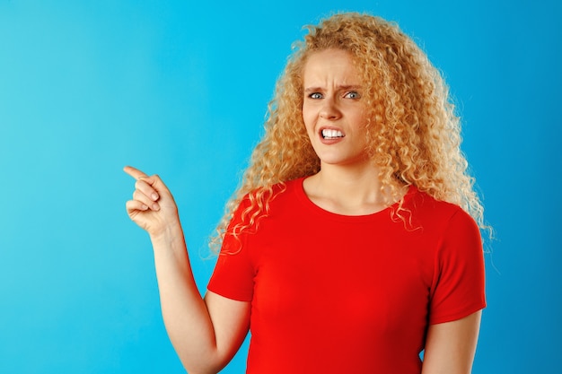 Junge attraktive blonde Frau, die ihren Finger zeigt, um Raumnahaufnahme zu kopieren