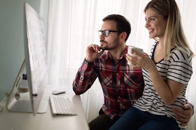 Junge attraktive Designer arbeiten von zu Hause aus zusammen